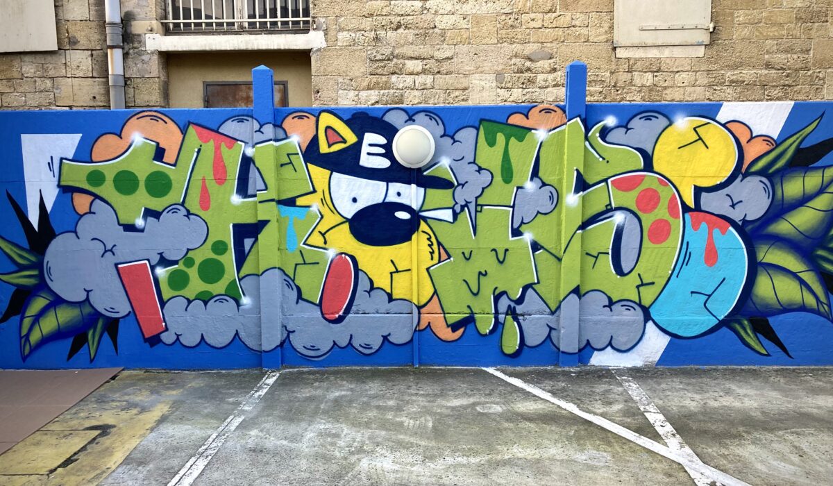 Fresque graffiti colorée réalisée en atelier participatif sur un mur de parking chez Zolpan à Bordeaux.