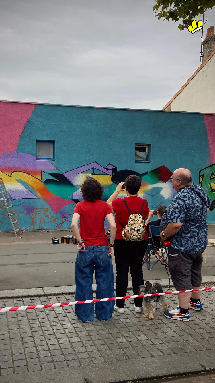 Visiteurs regardant la réalisation d’une fresque graffiti lors de la JAM D’ARC 2025 à Cenon.