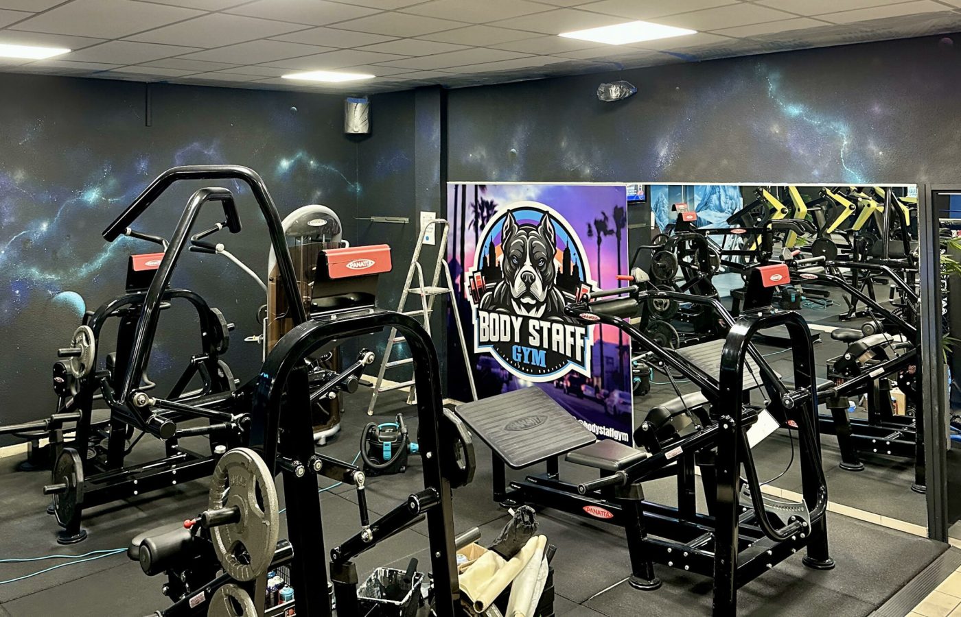 Mur décoré avec fresque cosmos et identité visuelle Body Staff Gym.