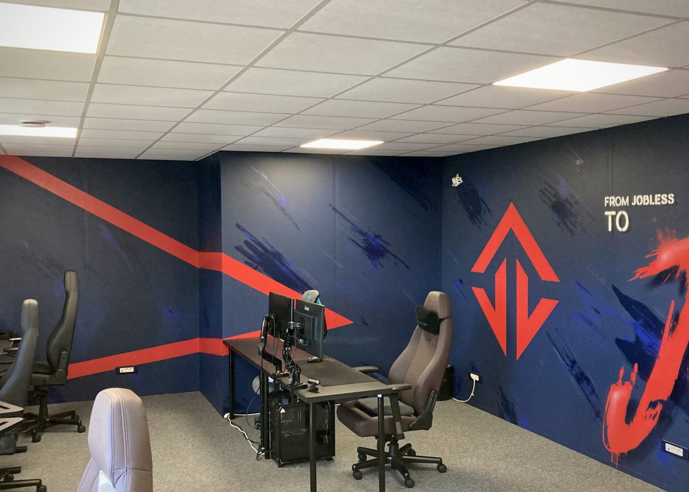 Salle e-sport transformée avec fresque murale immersive et branding JOBLIFE.