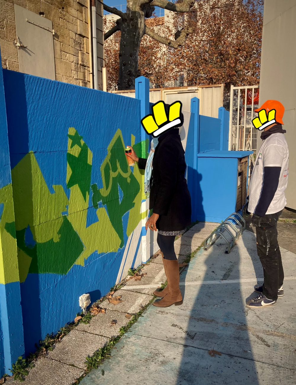 Passante découvrant le graffiti lors d’un atelier participatif encadré par un artiste sur une fresque à Bordeaux.